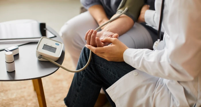 Doctor taking blood pressure for patient, freepik